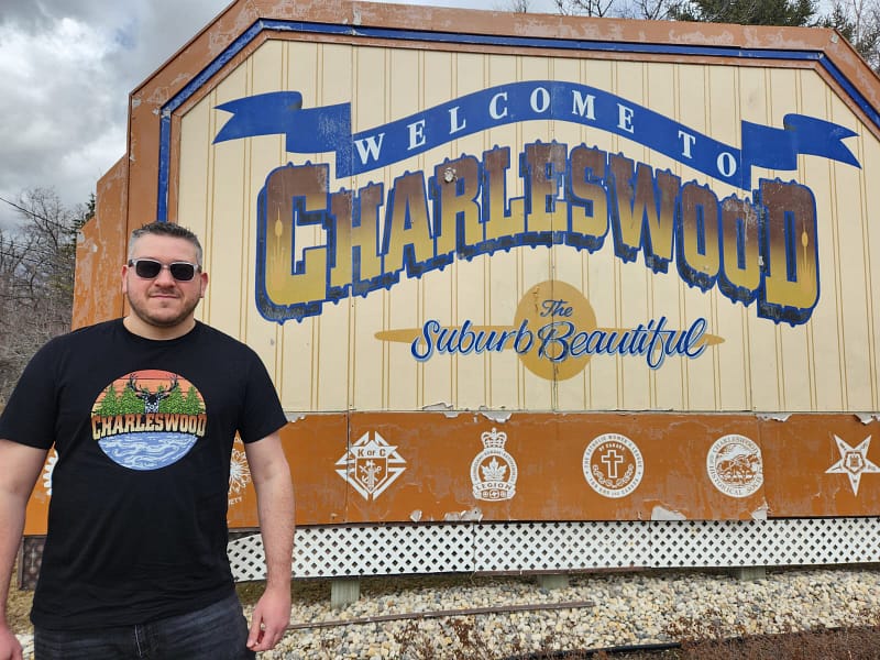 A photo Assaf Duvdevani in front of the Charleswood sign in Winnipeg